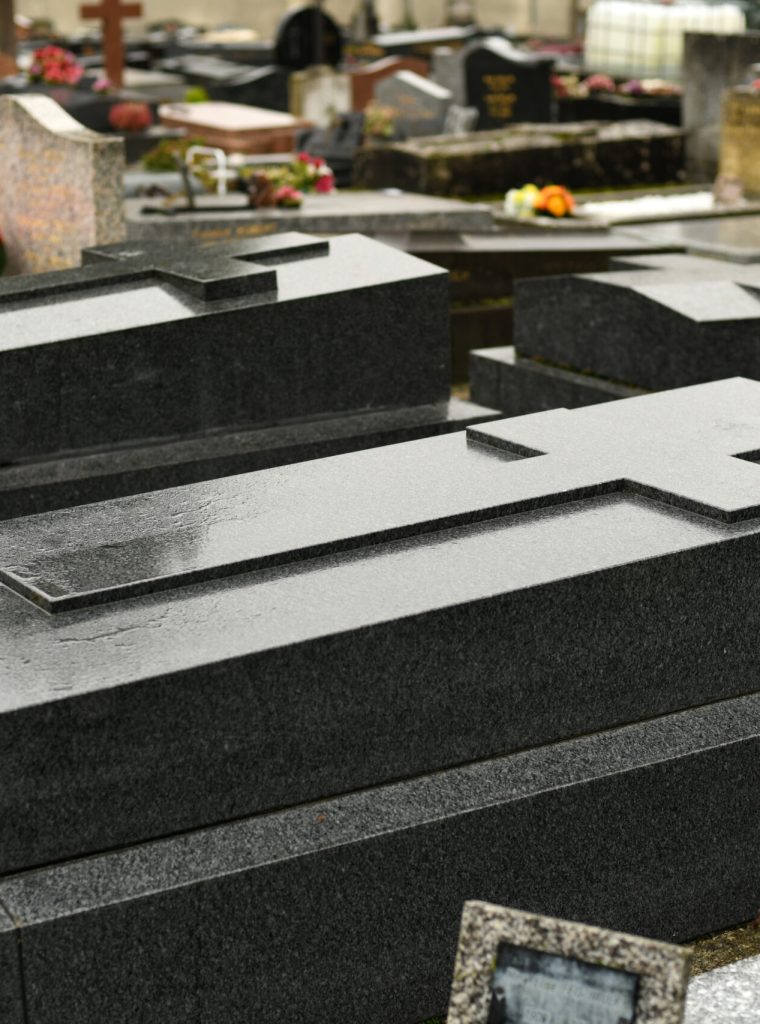 Cross on a black marble slab on a grave in a cemetery Cross on a marble slab on a grave in a cemetery